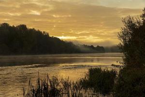 Morgennebel auf der Oberfläche des Flusses foto