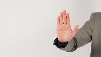 die hand tut nein oder stoppt ein handzeichen in einem grauen anzug auf weißem hintergrund. foto