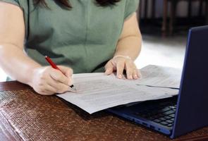 hand, die stiftmarkierung auf papierkram im büro hält foto