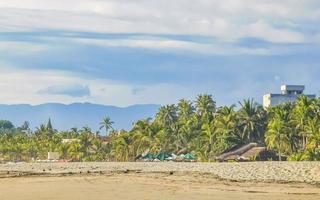 Palmen Sonnenschirme Liegestühle Strandresort Zicatela Puerto Escondido Mexiko. foto