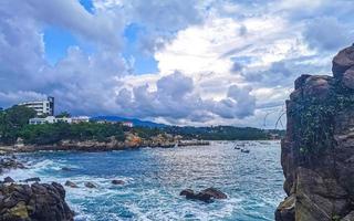 schöne surferwellen felsen klippen am strand puerto escondido mexiko. foto