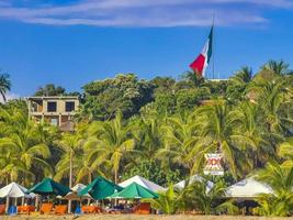 puerto escondido oaxaca mexiko 2022 palmen sonnenschirme sonnenliegen strandresort zicatela puerto escondido mexiko. foto