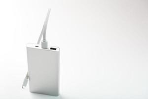 Powerbank zum Aufladen mobiler Geräte mit Kabel, auf weißem Hintergrund. foto