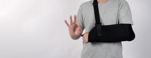 gebrochener Arm. Armschlingentherapieunterstützung und bedeckt um den ersten Knöchel des Ellbogens gebrochener Arm. foto