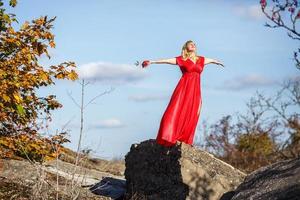 Luftbild auf Mädchen in rotem Kleid auf Felsen oder Beton zerstörte Struktur foto