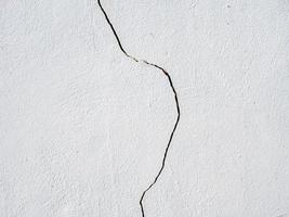 Foto eines senkrechten Risses an einer weißen Wand