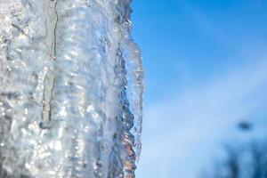 großer Eiszapfen auf blauem Hintergrund des bewölkten Himmels foto