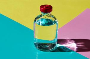 eine Blase mit einer transparenten Flüssigkeit auf einem farbigen Hintergrund. der Begriff eines Arzneimittels. foto