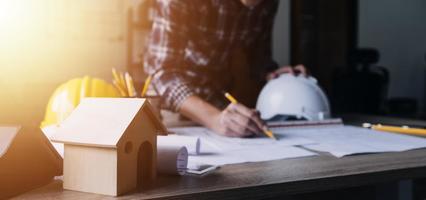 Bauingenieur, der an der Blaupause arbeitet, um große Geschäftsgebäude im Büro zu bauen. Engineering-Tools und Konstruktionskonzept. foto