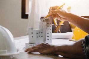 Bauingenieur, der an der Blaupause arbeitet, um große Geschäftsgebäude im Büro zu bauen. Engineering-Tools und Konstruktionskonzept. foto