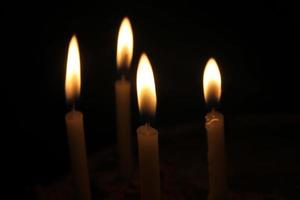 Kerzen brennen hell auf schwarzem Hintergrund foto