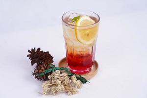 frischer Cocktail mit Zitronenscheibe in transparentem Glas mit weißem Hintergrund foto