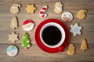 frohe weihnachten mit hausgemachten keksen und kaffeetasse auf holztischhintergrund. weihnachtsabend, party, urlaub und frohes neues jahr-konzept foto