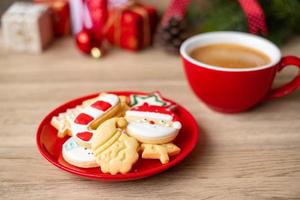 frohe weihnachten mit hausgemachten keksen und kaffeetasse auf holztischhintergrund. weihnachtsabend, party, urlaub und frohes neues jahr-konzept foto