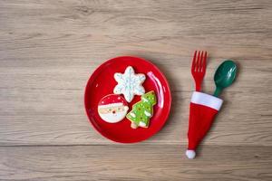 frohe weihnachten mit hausgemachten keksen, gabel und löffel auf holztischhintergrund. weihnachts-, party- und frohes neues jahrkonzept foto