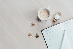 Tagebuch, eine Tasse Kaffee und eine Uhr foto