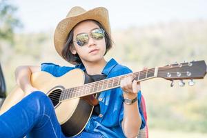 nahaufnahme frau trägt hut und spielt gitarre foto