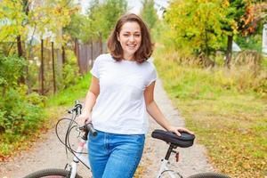 junge frau, die fahrrad im sommerstadtpark draußen fährt. aktive Menschen. Hipster-Mädchen entspannen und Fahrrad fahren. Radfahren zur Arbeit am Sommertag. fahrrad- und ökologie-lifestyle-konzept. foto