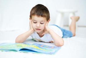 kleiner Junge liest ein Buch foto