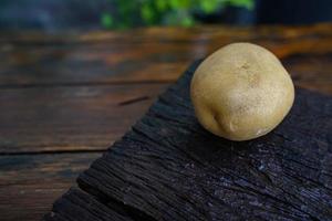 Ernährung mit rohen Kartoffeln. frische Kartoffeln auf Holzboden. Platz für Nachrichten. rohe Kartoffeln, die in vielen Gerichten verwendet werden können. foto