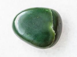 Kiesel aus grünem Nephrit-Edelstein auf Weiß foto