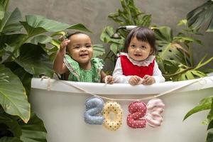 zwei vielfalt baby kleinkind sitzt zusammen mit 2023 frohes neues jahr zeichen für saisonfeier für glück und kinderkonzept foto