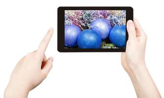 Machen Sie ein Foto von blauen Weihnachtsdekorationen mit einem Tablet-PC
