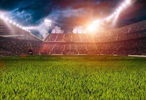 Fußballplatz im Sportstadion. Rasen, der in der Mitte von den umgebenden Lichtern beleuchtet wird. foto