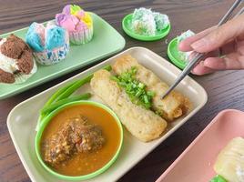 traditionelle indonesische Snacks. mit stäbchen gegessene risole, japanisches besteck mit grüner chilisoße foto