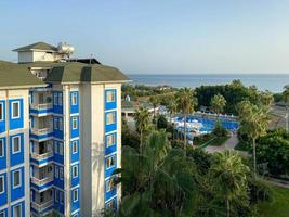 Wunderschöner tropischer Blick von oben vom Balkon des Hotels auf das Resort zum Entspannen in einem warmen tropischen Land mit Pool und Palmen mit dem Meer