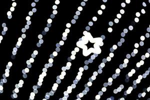 Unfokussiertes abstraktes weißes Bokeh mit Lichtstern auf schwarzem Hintergrund. defokussiert und verschwommen viele runde licht foto