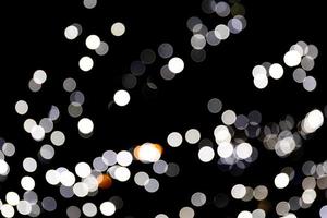 abstraktes Licht Bokeh als Hintergrund defokussiert und verschwommen viele runde Lichter auf schwarzem Hintergrund foto