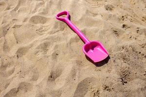 rosa Sandspielzeug am Strand. Ferientag foto