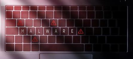 Banner-Draufsicht auf die Laptop-Tastatur mit Malware-Nachricht auf Tasten und rotem Licht. Sicherheitswarnung Datenschutz Geschäftstechnologie. foto