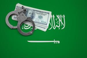 saudi-arabien-flagge mit handschellen und einem bündel dollar. das Konzept des Gesetzesbruchs und der Diebesverbrechen foto