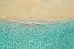 entspannende Luftstrandszene, Sommerferienferien-Vorlagenfahne. Wellen surfen mit erstaunlicher blauer Ozeanlagune, Meeresküste, Küste. perfekte luftdrohne draufsicht. friedlicher heller Strand, Meer foto