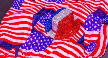 glitzernder roter, weißer und blauer Partyhut auf Schal mit amerikanischer Flagge foto