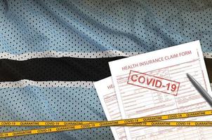 botswana-flagge und krankenversicherungsantragsformular mit covid-19-stempel. Coronavirus- oder 2019-ncov-Viruskonzept
