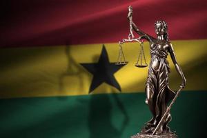 Ghana-Flagge mit Statue der Justitia und Gerichtswaage im dunklen Raum. Konzept von Urteil und Bestrafung foto