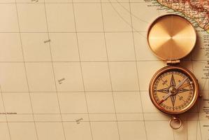 antiker Messingkompass über alter Karte foto