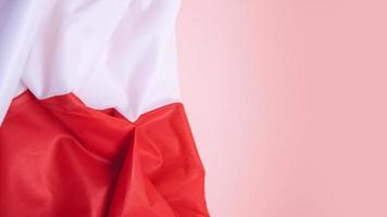 gefaltete Flagge Polens auf lachsfarbenem Hintergrund foto