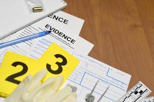 Papierkram während des Ermittlungsprozesses am Tatort im CSI-Labor. Beweisetiketten mit Fingerabdruck-Antragsteller und Gummihandschuhen auf Vooden-Tisch foto