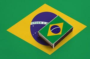 die brasilienflagge ist auf einer streichholzschachtel abgebildet, die auf einer großen flagge liegt foto