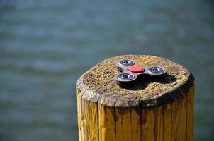 Ein hölzerner Spinner liegt auf einer Holzstange vor dem Hintergrund von Flusswasser foto