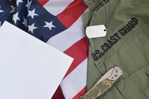 militärische hundemarke und messer liegen auf der alten uniform der us-küstenwache und der gefalteten flagge der vereinigten staaten foto
