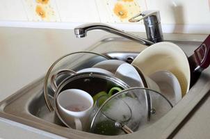Schmutziges Geschirr und ungewaschene Küchengeräte füllten die Küchenspüle foto