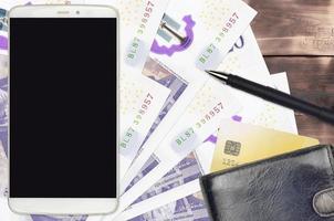 20 britische Pfund-Scheine und Smartphone mit Geldbörse und Kreditkarte. E-Payments oder E-Commerce-Konzept. Online-Shopping und Geschäfte mit tragbaren Geräten foto