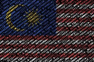 die malaysia-flagge wird auf dem bildschirm mit dem programmcode dargestellt. das konzept der modernen technologie und standortentwicklung foto