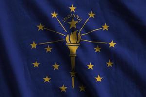 indiana us-staatsflagge mit großen falten, die in der nähe unter dem studiolicht im innenbereich wehen. die offiziellen symbole und farben im banner foto