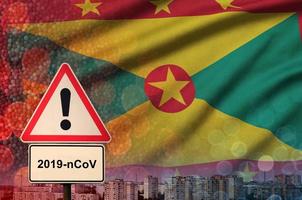 Grenada-Flagge und Coronavirus 2019-ncov-Warnzeichen. konzept der hohen wahrscheinlichkeit eines neuartigen coronavirus-ausbruchs durch reisende touristen foto